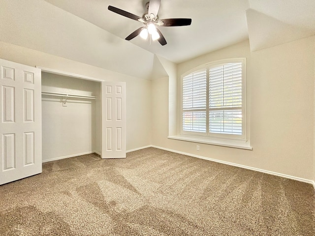 unfurnished bedroom with carpet flooring, ceiling fan, a closet, and vaulted ceiling