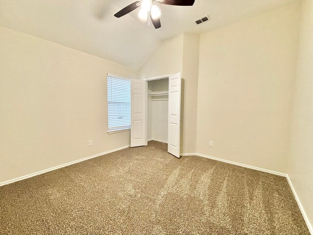 unfurnished bedroom featuring carpet, a closet, ceiling fan, and lofted ceiling