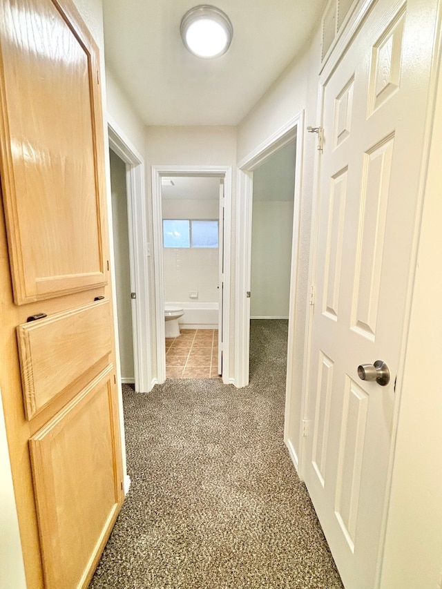 corridor featuring dark colored carpet