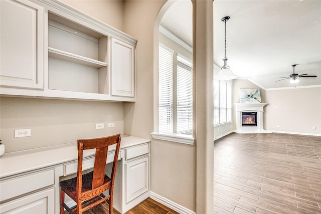 office area featuring ornamental molding, a wealth of natural light, and built in desk