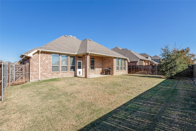 rear view of house with a yard and a patio