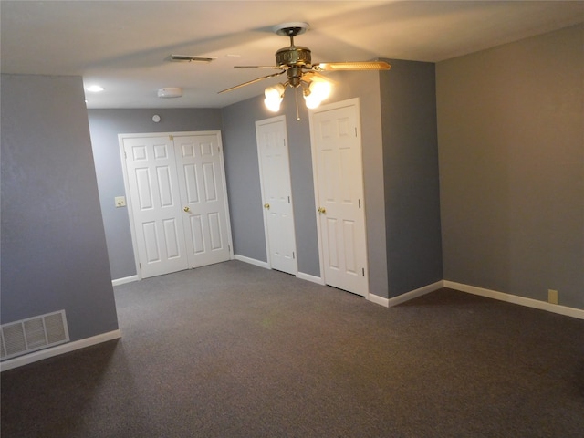 interior space featuring dark colored carpet and ceiling fan