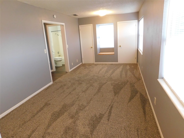 carpeted empty room with a textured ceiling