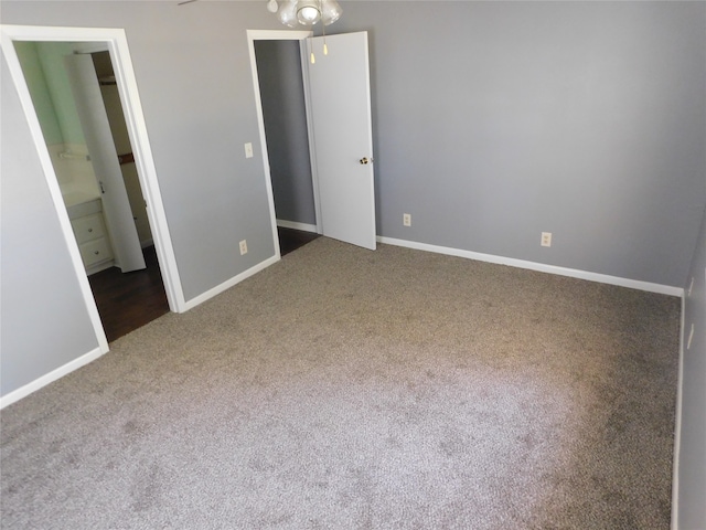 unfurnished bedroom featuring connected bathroom and carpet