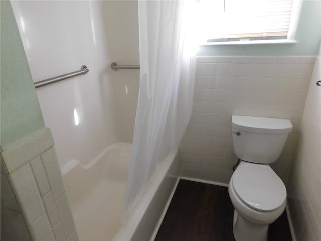 bathroom featuring hardwood / wood-style floors, toilet, tile walls, and shower / tub combo