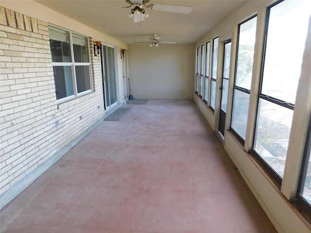 unfurnished sunroom featuring ceiling fan