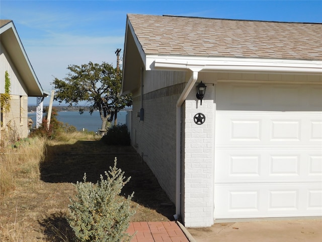 view of property exterior featuring a garage and a water view