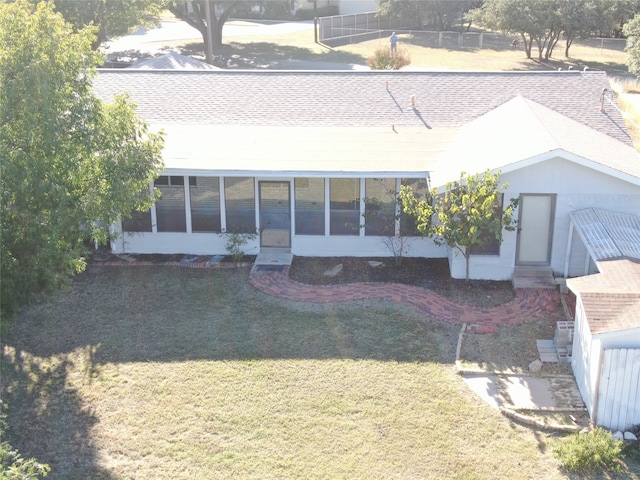 back of property with a lawn and a sunroom