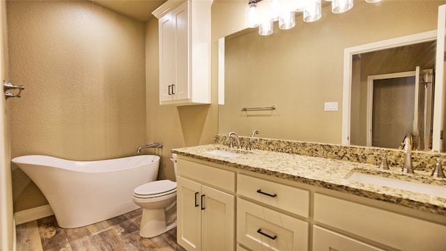 bathroom with hardwood / wood-style floors, vanity, toilet, and a bathing tub