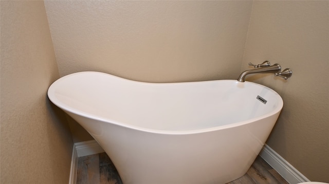 bathroom with wood-type flooring and a bathing tub