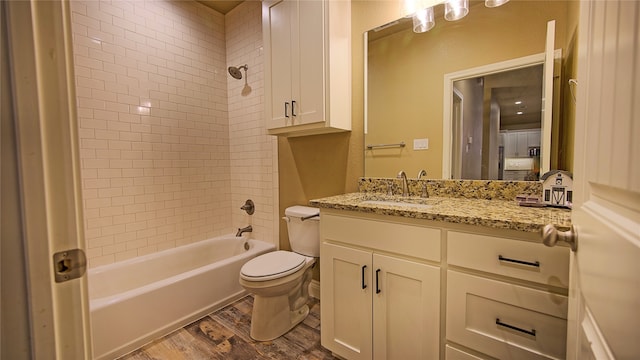 full bathroom with toilet, vanity, wood-type flooring, and tiled shower / bath