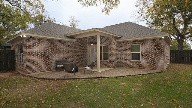 rear view of house featuring a lawn and a patio area