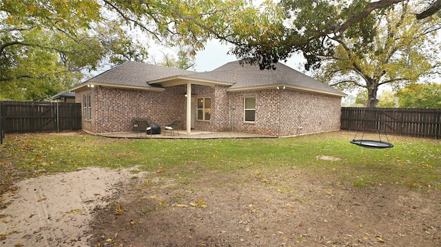 rear view of house with a lawn and a patio