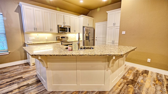 kitchen featuring white cabinets, appliances with stainless steel finishes, and an island with sink