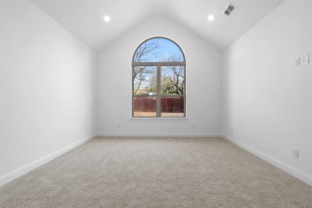 carpeted empty room featuring lofted ceiling