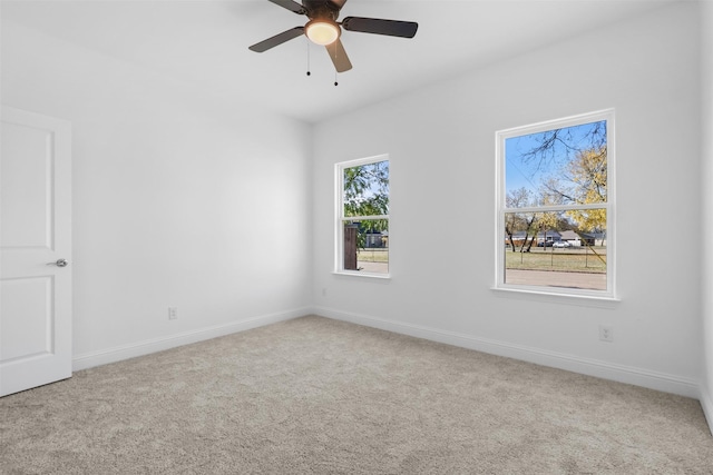 empty room featuring light colored carpet and ceiling fan