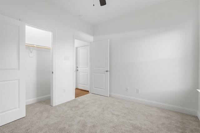 unfurnished bedroom featuring ceiling fan, a closet, and light colored carpet