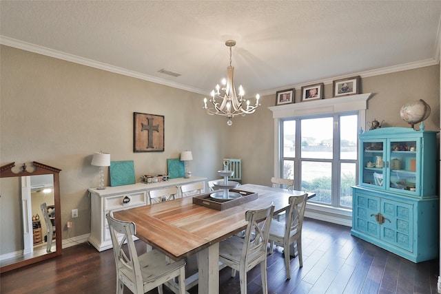 dining area with a textured ceiling, dark hardwood / wood-style floors, an inviting chandelier, and ornamental molding