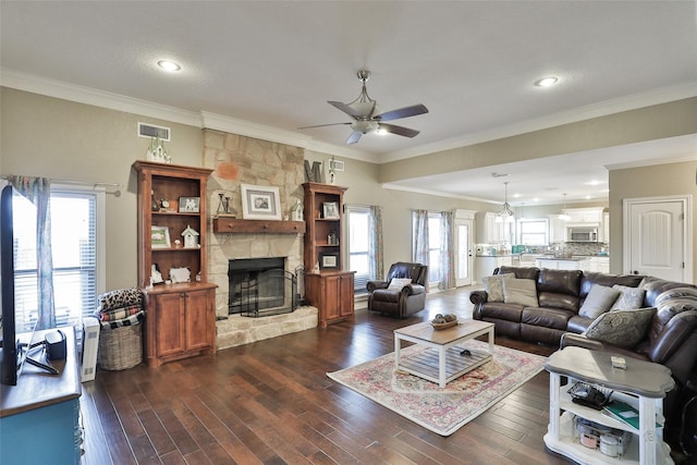 living room with ceiling fan, dark hardwood / wood-style flooring, ornamental molding, and a fireplace