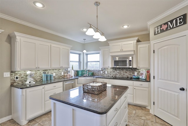 kitchen with white cabinetry, sink, a center island, stainless steel appliances, and crown molding