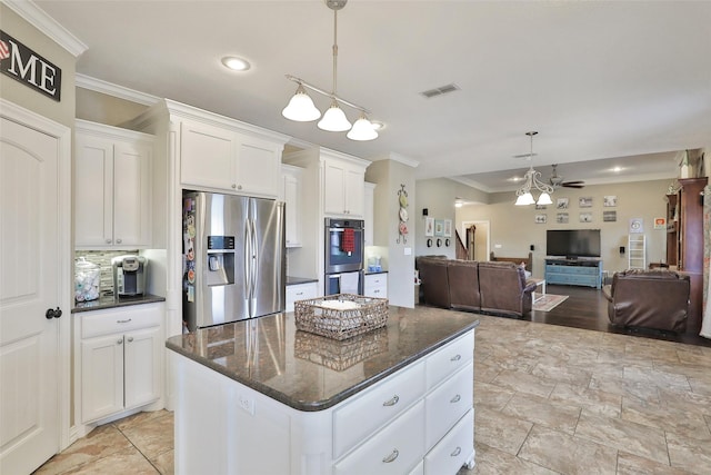 kitchen with a center island, white cabinets, ceiling fan, appliances with stainless steel finishes, and decorative light fixtures