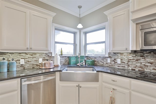 kitchen with tasteful backsplash, white cabinets, and appliances with stainless steel finishes