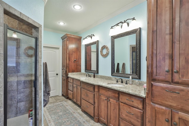 bathroom with tile patterned floors, vanity, a tile shower, and ornamental molding