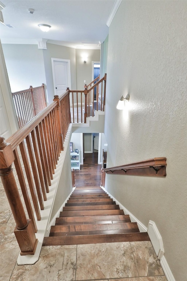 stairs featuring hardwood / wood-style flooring and crown molding