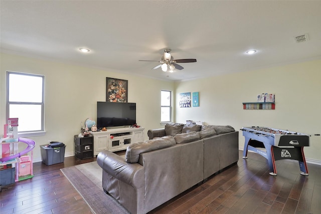 living room featuring ornamental molding, plenty of natural light, dark wood-type flooring, and ceiling fan