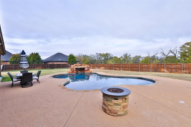 view of swimming pool featuring a yard, an outdoor fire pit, and a patio area