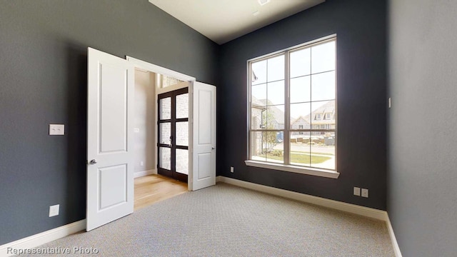 carpeted empty room featuring french doors