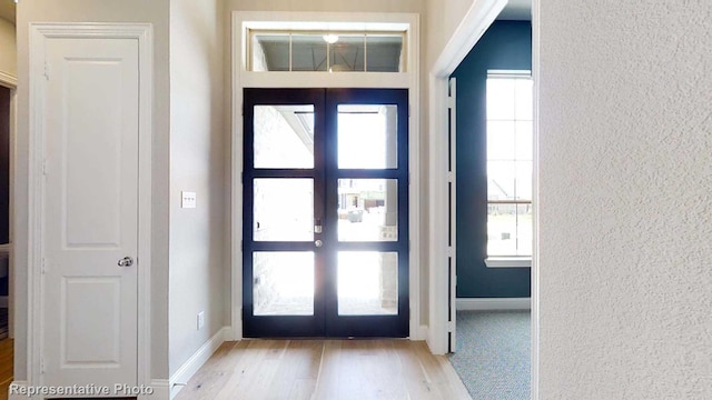 entrance foyer featuring a wealth of natural light, french doors, and light wood-type flooring