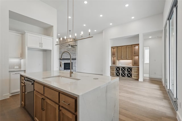 823 Shady Oaks Dr, Rockwall, TX 75087 - kitchen with a sink, backsplash, dishwasher, an island with sink, and brown cabinetry