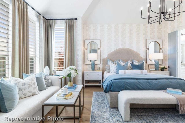 bedroom featuring hardwood / wood-style flooring, a notable chandelier, and multiple windows