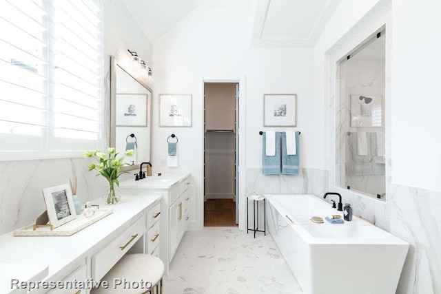 bathroom featuring separate shower and tub, tile walls, vanity, and lofted ceiling