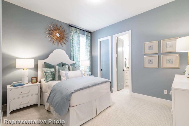 bedroom featuring connected bathroom and light carpet