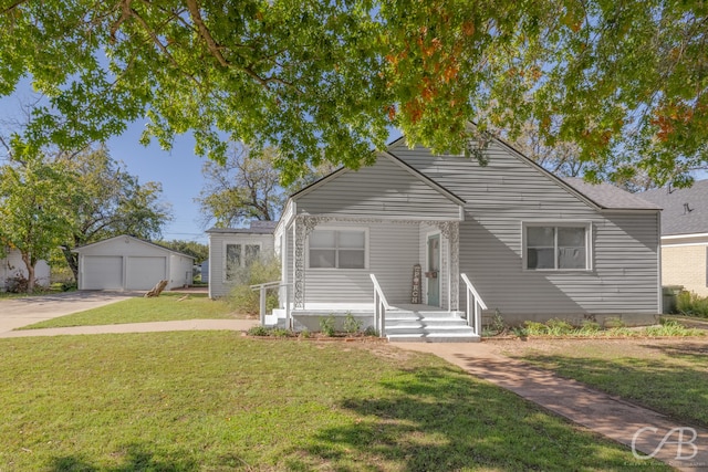 view of front facade featuring a front yard, a garage, and an outdoor structure