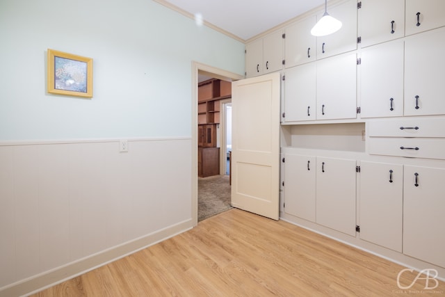 interior space with light hardwood / wood-style floors and crown molding