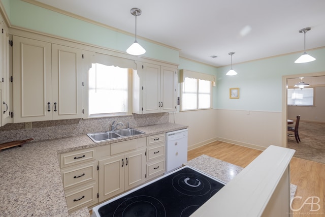 kitchen featuring crown molding, sink, dishwasher, light hardwood / wood-style floors, and hanging light fixtures