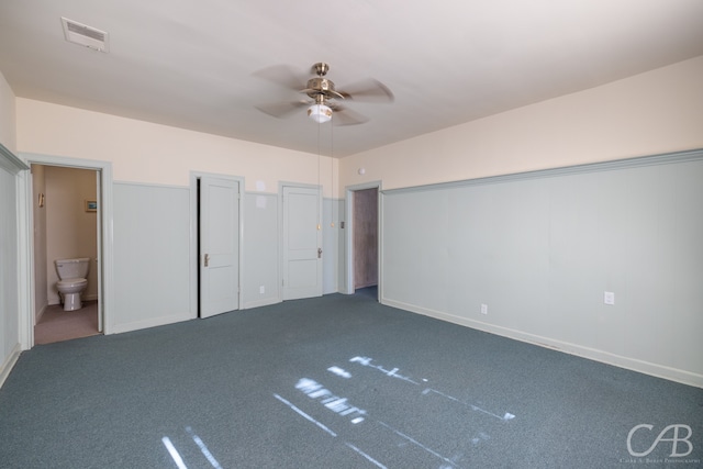 unfurnished bedroom featuring ensuite bath, ceiling fan, carpet, and multiple closets