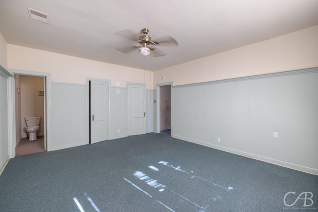 unfurnished bedroom featuring ensuite bath, ceiling fan, carpet, and multiple closets