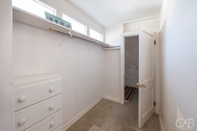 walk in closet featuring dark parquet flooring