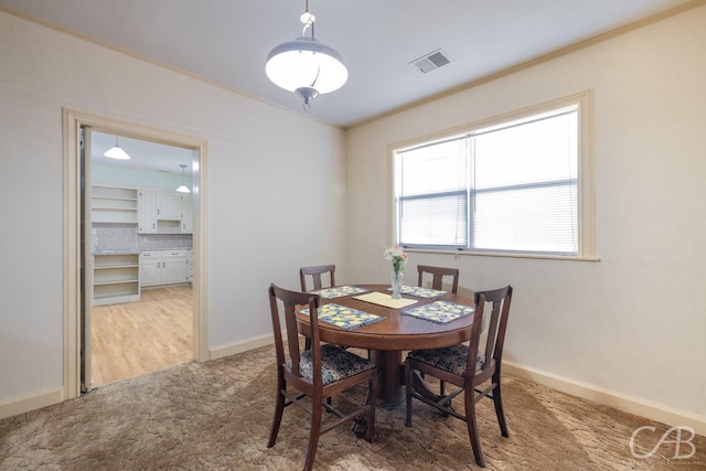 dining area with crown molding and light wood-type flooring