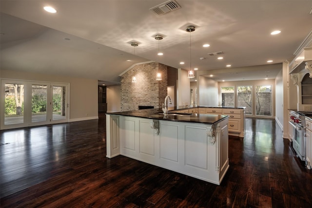 2516 Beefeater Dr, Wichita Falls, TX 76308 - kitchen featuring dark countertops, open floor plan, lofted ceiling, dark wood-style floors, and a large island with sink