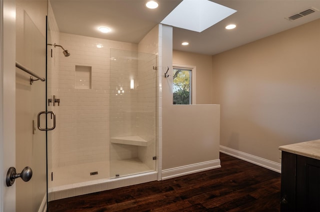2516 Beefeater Dr, Wichita Falls, TX 76308 - bathroom featuring a skylight, a shower stall, wood finished floors, vanity, and recessed lighting