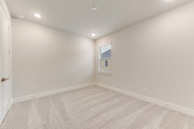 spare room featuring light colored carpet