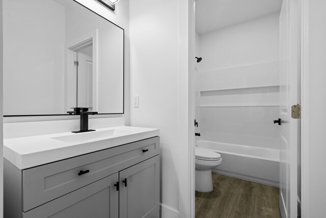 full bathroom with shower / bathing tub combination, toilet, vanity, and hardwood / wood-style flooring