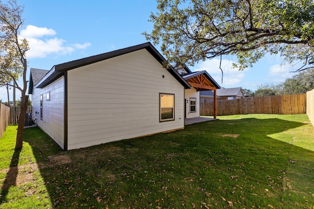 back of house with a lawn and a patio