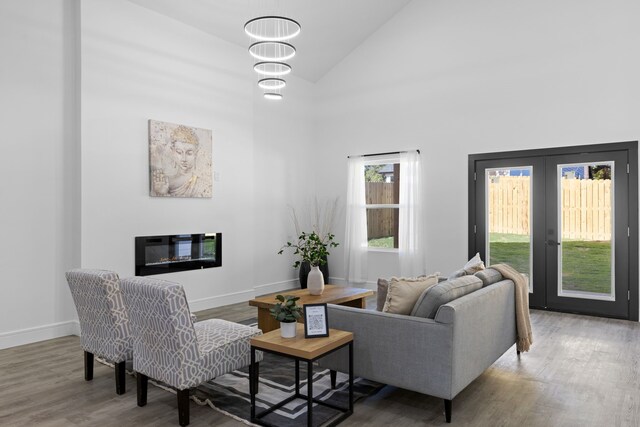 living room with a chandelier, high vaulted ceiling, and wood-type flooring