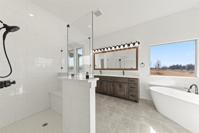 bathroom featuring tile patterned floors, vanity, shower with separate bathtub, and tile walls